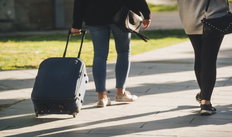 Imagen de dos personas con una maleta