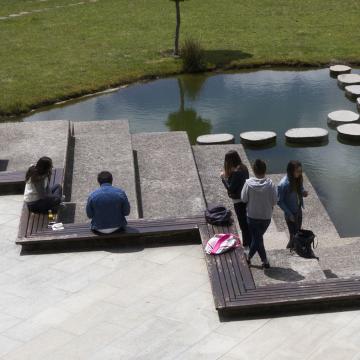 Varios alumnos e alumnas diante dun estanque nun dos campus