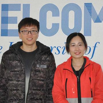 Un alumno e unha alumna procedentes de Asia diante dunha pancarta que pon Welcome