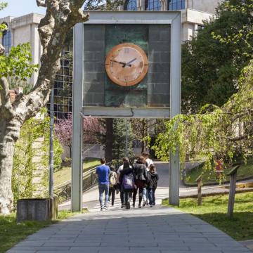 Estudantes pasan por baixo do emblemático reloxio do campus de Ourense