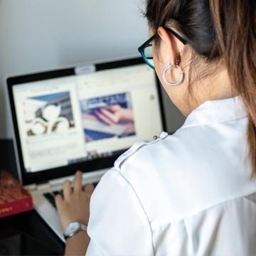 Estudante de costas traballando cun ordenador portátil